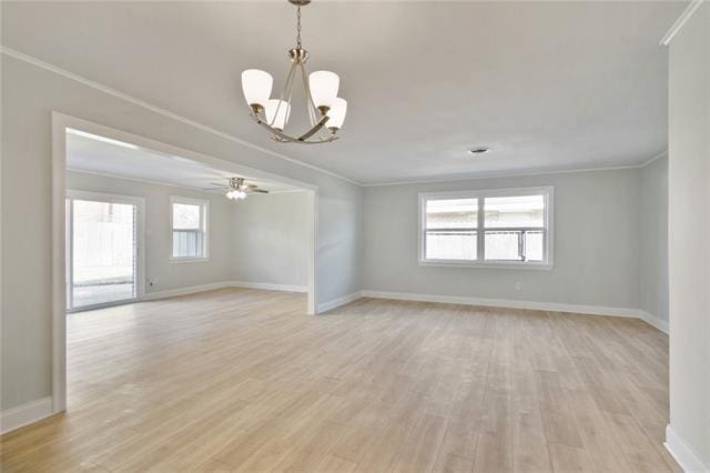 empty room featuring ornamental molding, light wood-type flooring, and ceiling fan with notable chandelier