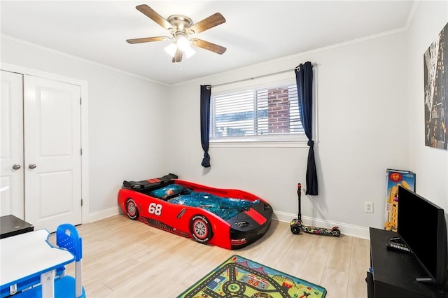 bedroom featuring a closet, wood-type flooring, ceiling fan, and crown molding