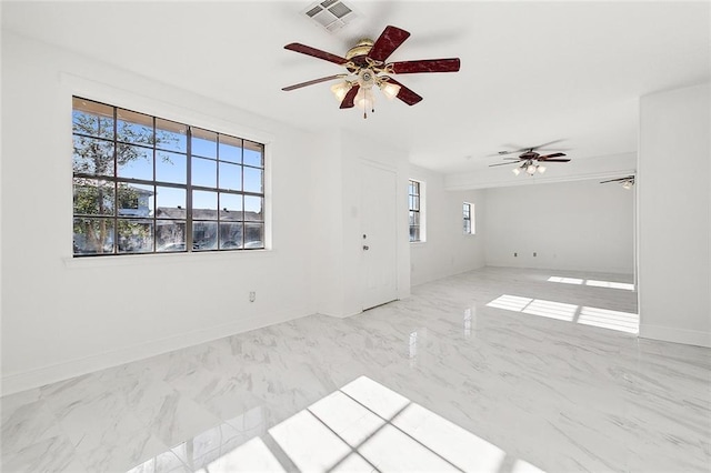 empty room featuring ceiling fan and a healthy amount of sunlight