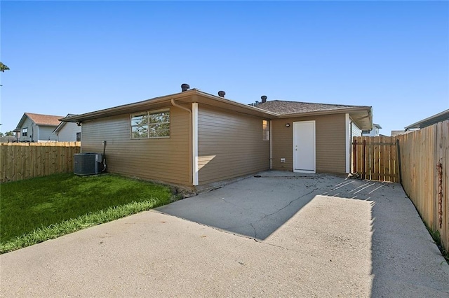 back of property with a patio, a yard, and central AC unit