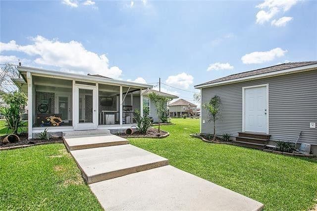 rear view of house with a sunroom and a yard