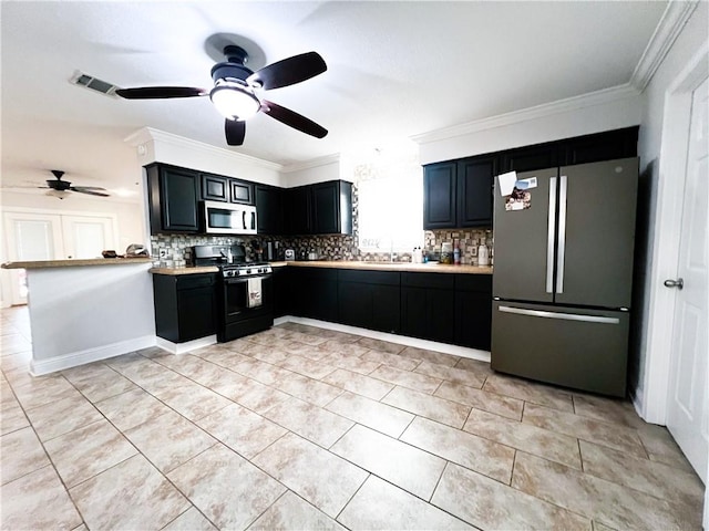 kitchen with ornamental molding, backsplash, ceiling fan, and appliances with stainless steel finishes