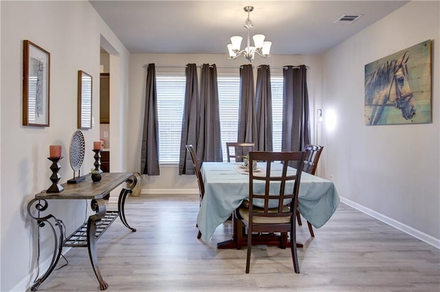 5572 Wake Reserve Rd, Slidell, LA 70461 - dining room with a chandelier, baseboards, and light wood-style floors