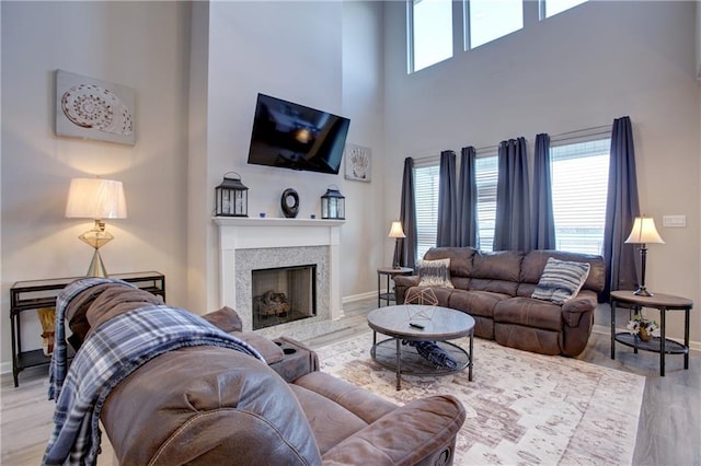 5572 Wake Reserve Rd, Slidell, LA 70461 - living area featuring wood finished floors, baseboards, a high ceiling, and a premium fireplace