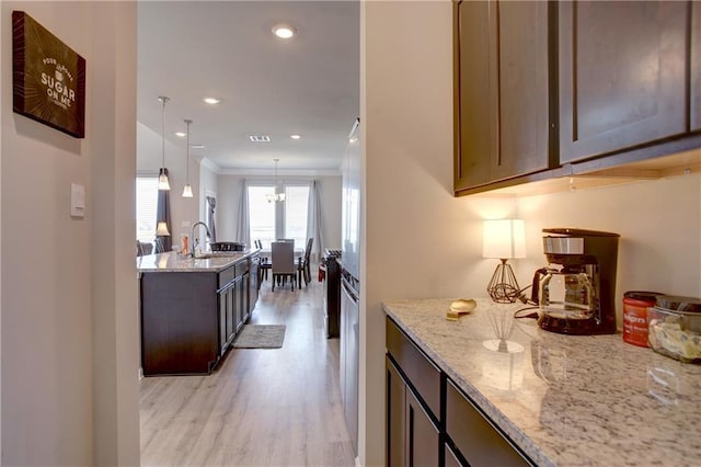 5572 Wake Reserve Rd, Slidell, LA 70461 - kitchen featuring a sink, light wood-style floors, light stone countertops, recessed lighting, and pendant lighting