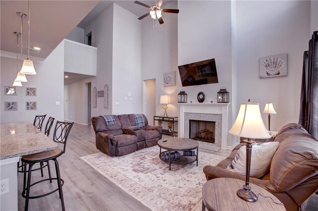 5572 Wake Reserve Rd, Slidell, LA 70461 - living room with light wood finished floors, a towering ceiling, ceiling fan, a fireplace, and baseboards