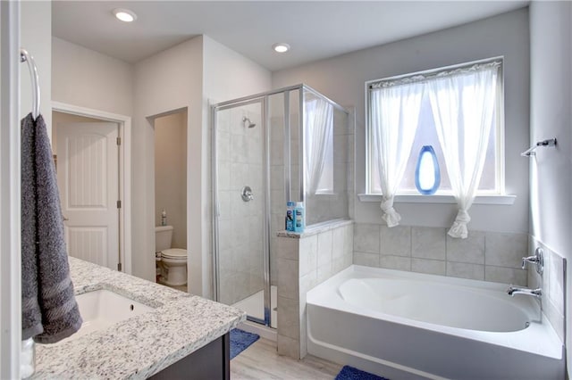 5572 Wake Reserve Rd, Slidell, LA 70461 - full bathroom featuring toilet, a shower stall, a bath, vanity, and wood finished floors