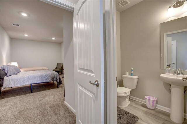 5572 Wake Reserve Rd, Slidell, LA 70461 - bedroom with baseboards, wood finished floors, a sink, and recessed lighting