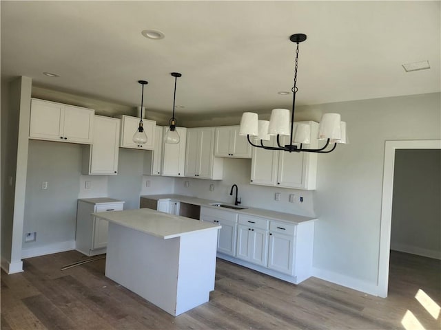 kitchen featuring a center island, white cabinetry, sink, and light hardwood / wood-style flooring