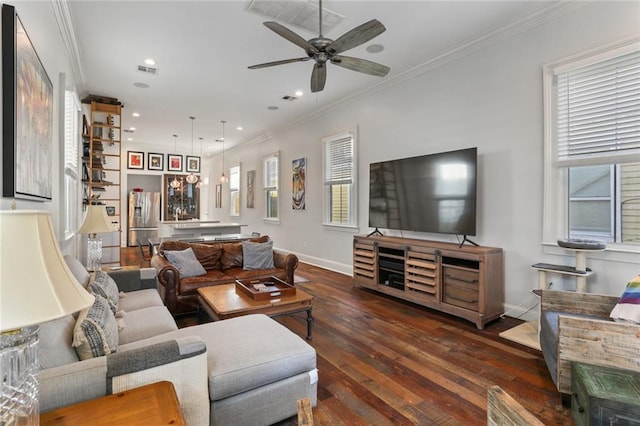 living room with crown molding, dark hardwood / wood-style flooring, ceiling fan, and plenty of natural light