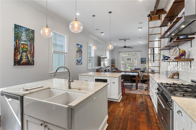 kitchen with stainless steel appliances, white cabinets, plenty of natural light, and decorative light fixtures