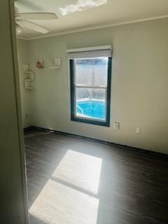 empty room featuring hardwood / wood-style flooring, crown molding, and ceiling fan