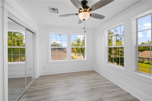 unfurnished sunroom featuring plenty of natural light and ceiling fan