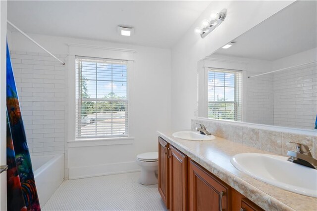 full bathroom featuring tile patterned floors, plenty of natural light, vanity, and toilet