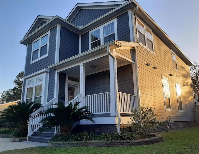 view of side of property featuring covered porch