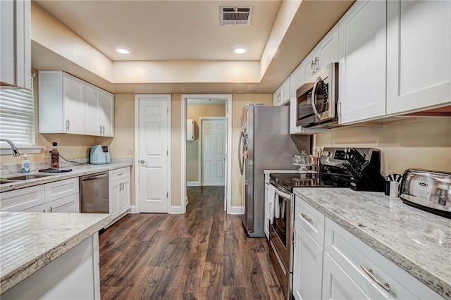 kitchen featuring light stone counters, dark hardwood / wood-style floors, sink, white cabinetry, and stainless steel appliances