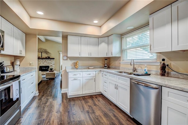 213 Surrey Dr, La Place, LA 70068 - kitchen with appliances with stainless steel finishes, white cabinetry, dark wood finished floors, a sink, and recessed lighting
