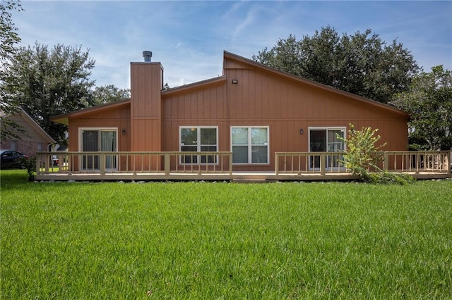 213 Surrey Dr, La Place, LA 70068 - back of property featuring a wooden deck, a chimney, and a lawn