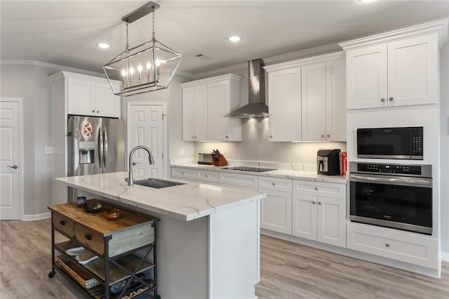 kitchen with sink, white cabinetry, wall chimney range hood, a center island with sink, and appliances with stainless steel finishes