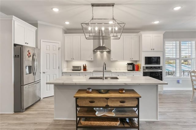 kitchen with appliances with stainless steel finishes, decorative light fixtures, a kitchen island with sink, and white cabinetry