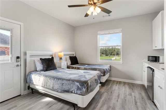 bedroom with ceiling fan, light wood-type flooring, and multiple windows