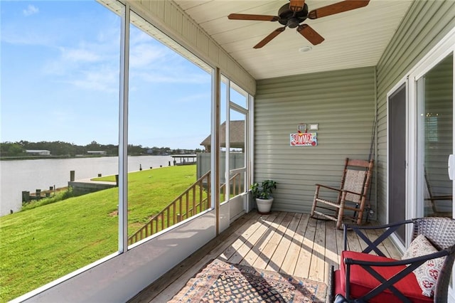 sunroom / solarium featuring ceiling fan and a water view