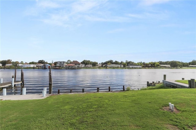 dock area with a water view and a yard