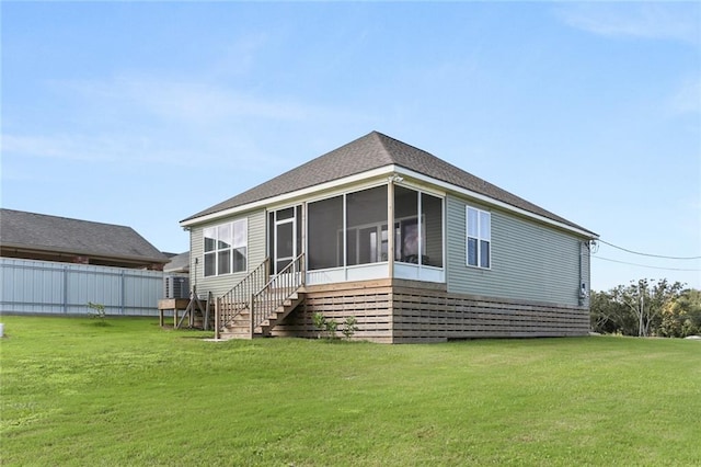 rear view of property with a sunroom and a yard