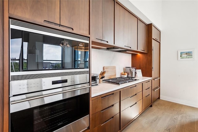 kitchen featuring light wood-type flooring and appliances with stainless steel finishes