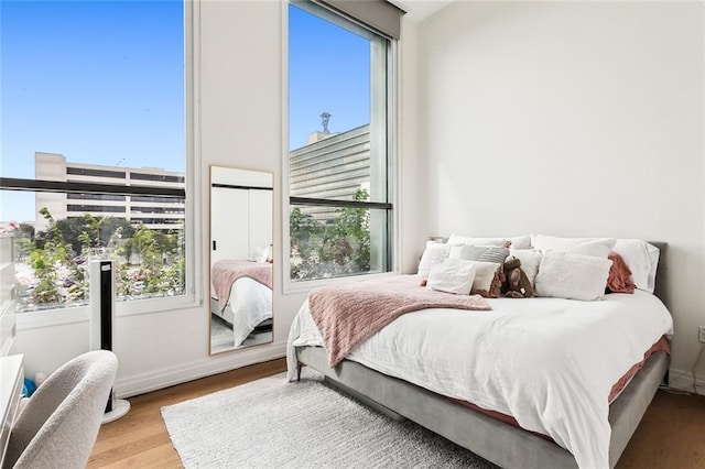 bedroom featuring multiple windows and light hardwood / wood-style flooring