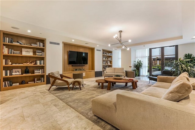 living room with built in shelves and a notable chandelier