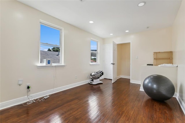 workout area with plenty of natural light and dark hardwood / wood-style floors