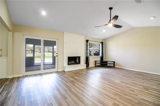 unfurnished living room featuring a fireplace, light hardwood / wood-style floors, ceiling fan, and lofted ceiling