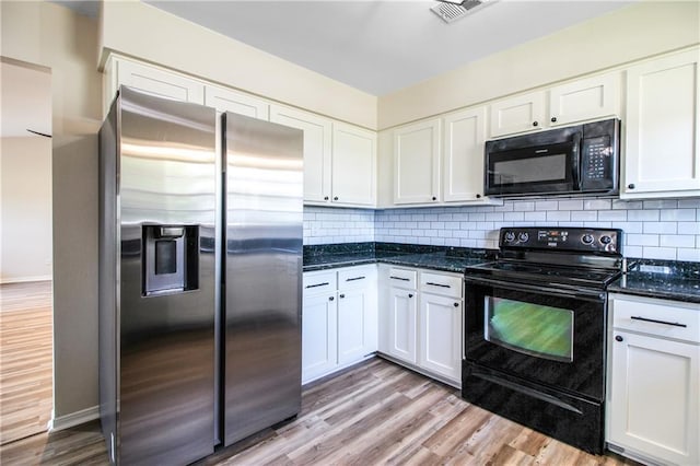 kitchen with dark stone countertops, decorative backsplash, white cabinets, and black appliances