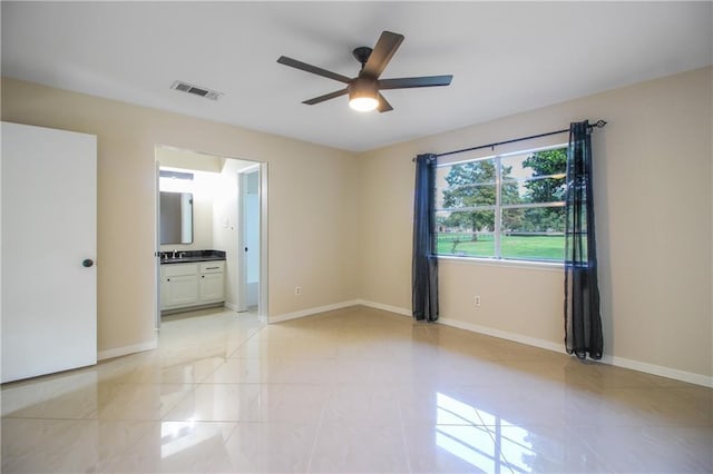 spare room featuring ceiling fan, light tile patterned floors, and sink