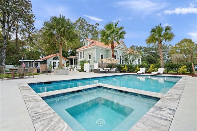 view of swimming pool with exterior bar, a patio, and an in ground hot tub