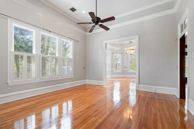 spare room featuring ceiling fan with notable chandelier, hardwood / wood-style floors, and crown molding