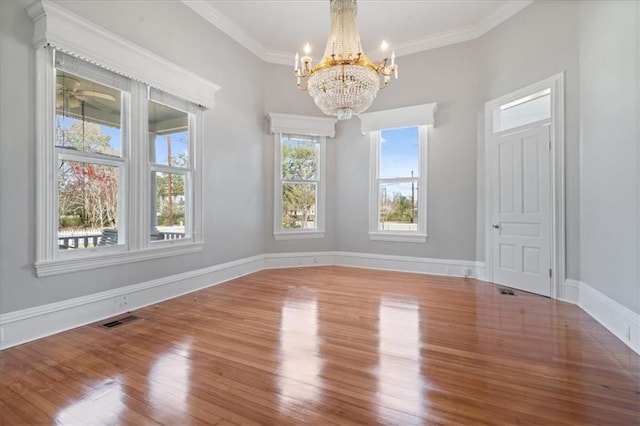 unfurnished room with wood-type flooring, a chandelier, and crown molding