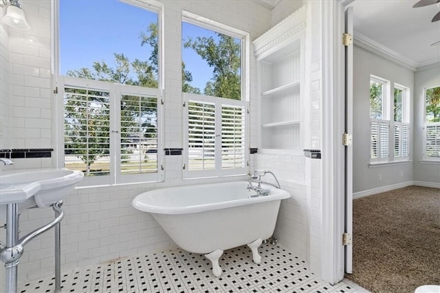 bathroom with tile walls, a bath, and a wealth of natural light