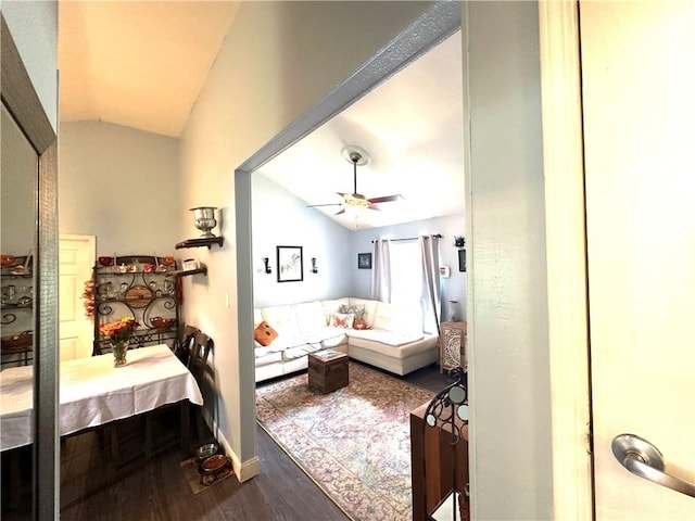 living room featuring lofted ceiling, ceiling fan, and dark wood-type flooring