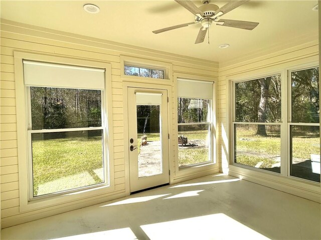 unfurnished sunroom with ceiling fan