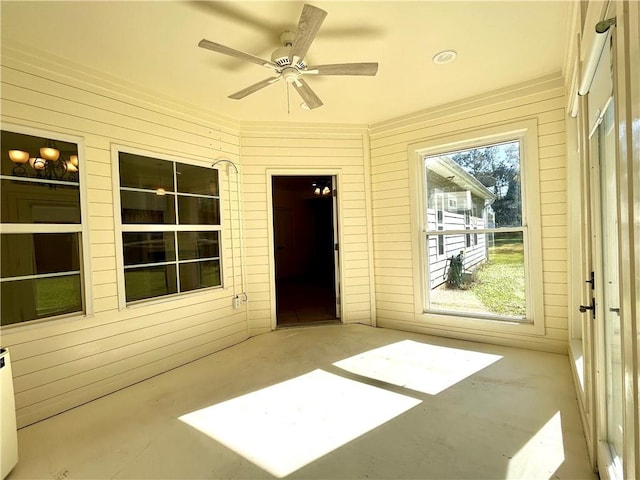 unfurnished sunroom featuring ceiling fan and a healthy amount of sunlight