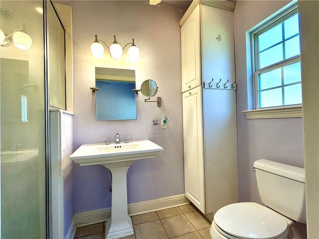 bathroom with toilet, tile patterned flooring, and an enclosed shower