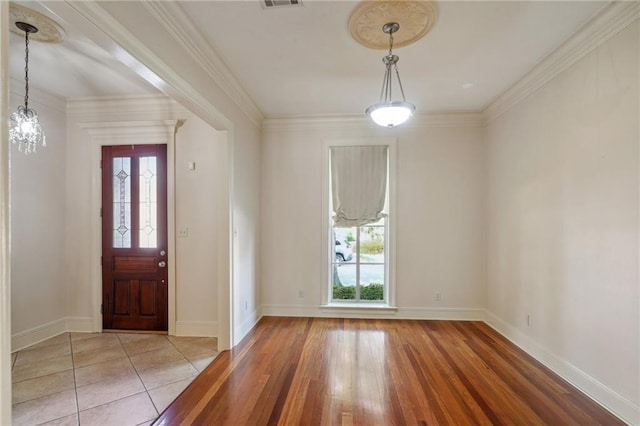 foyer entrance with a notable chandelier, crown molding, and hardwood / wood-style flooring