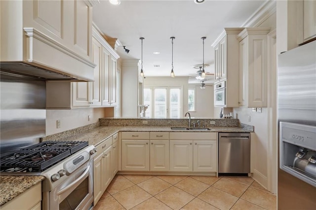 kitchen with stainless steel appliances, ceiling fan, decorative light fixtures, and cream cabinetry