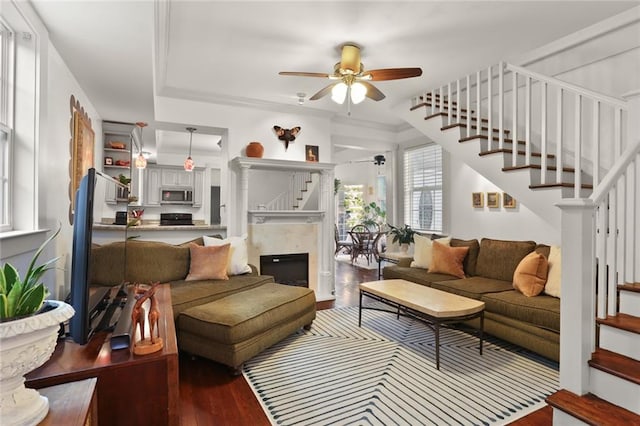 living room featuring ceiling fan, hardwood / wood-style flooring, and a premium fireplace