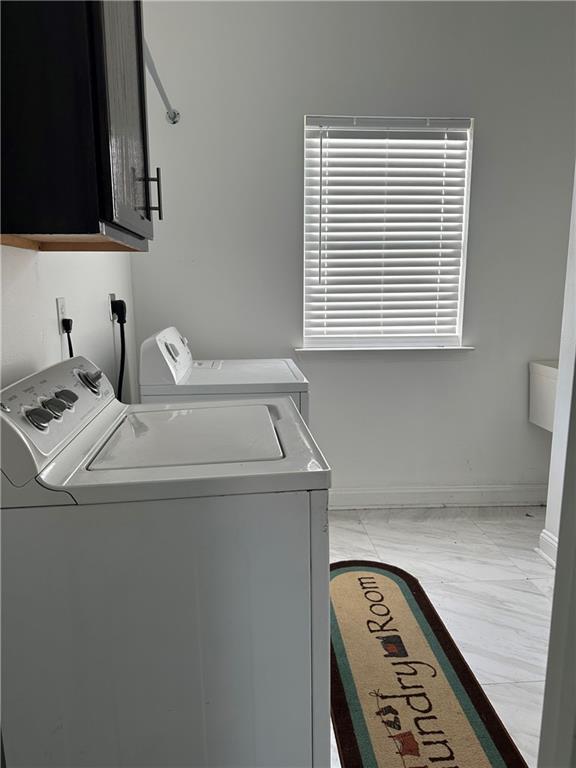 laundry room featuring cabinets and separate washer and dryer