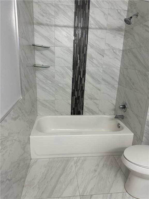 bathroom featuring tiled shower / bath and toilet