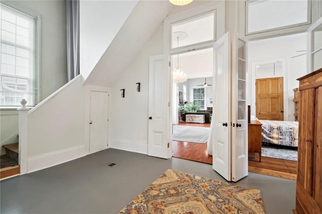 entryway featuring vaulted ceiling, a notable chandelier, and dark wood-type flooring