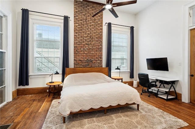 bedroom with ceiling fan, hardwood / wood-style flooring, and multiple windows